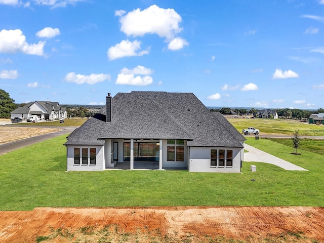 rear view of property with a lawn