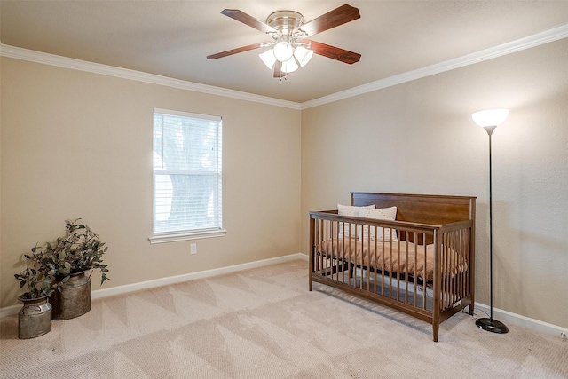 bedroom with ornamental molding, light colored carpet, a nursery area, and ceiling fan