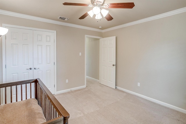 unfurnished bedroom with ornamental molding, light colored carpet, ceiling fan, and a closet