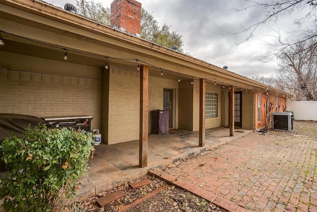 back of property with central AC and a patio area