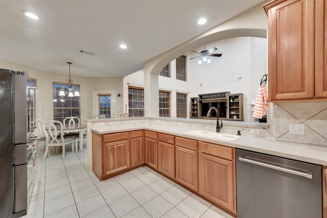 kitchen with sink, decorative light fixtures, appliances with stainless steel finishes, kitchen peninsula, and ceiling fan with notable chandelier