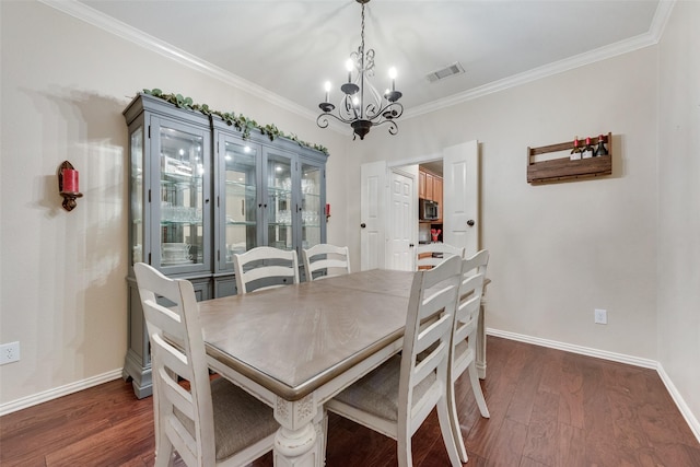 dining room featuring dark wood-type flooring, crown molding, and a chandelier