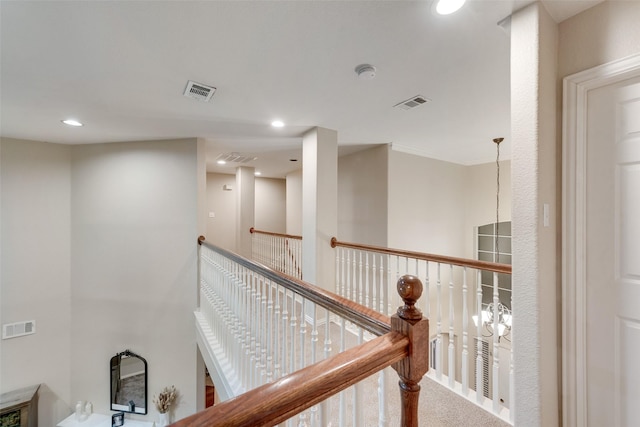 corridor with an inviting chandelier and carpet flooring