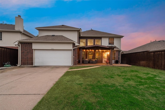 back house at dusk with a garage, outdoor lounge area, a yard, and central air condition unit