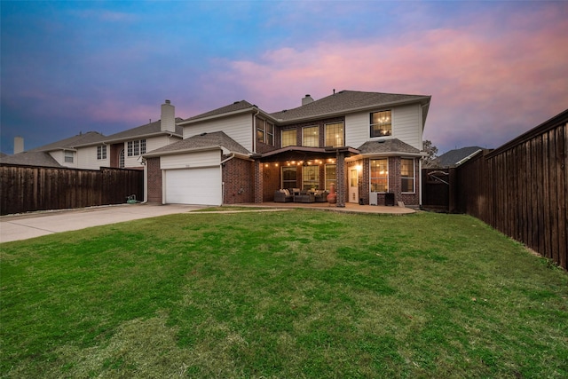 view of front of property featuring a garage, a yard, cooling unit, and an outdoor living space