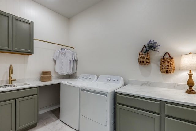 clothes washing area featuring sink, light tile patterned floors, cabinets, and washing machine and clothes dryer