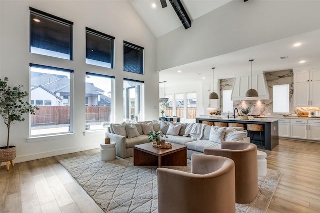 living room featuring high vaulted ceiling, a wealth of natural light, and light hardwood / wood-style floors