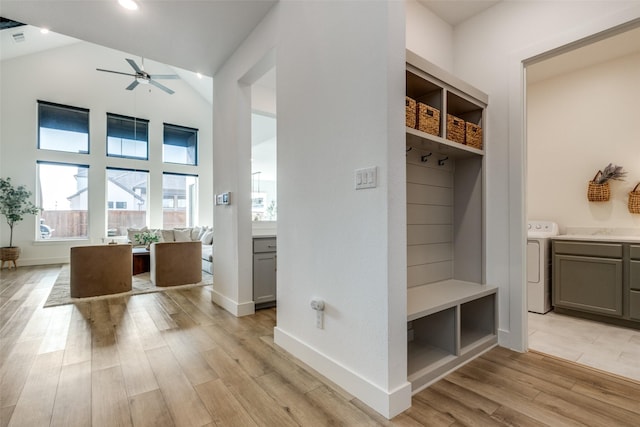 mudroom featuring ceiling fan, washer / dryer, high vaulted ceiling, and light hardwood / wood-style floors