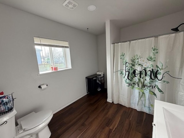 full bath featuring visible vents, toilet, wood finished floors, a shower with curtain, and baseboards