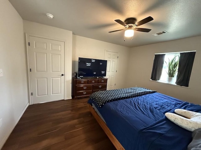 bedroom featuring a ceiling fan, baseboards, visible vents, and dark wood-style flooring