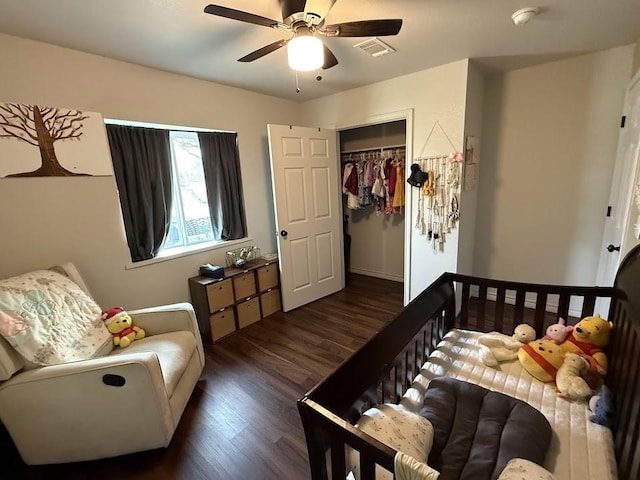 bedroom featuring a closet, wood finished floors, visible vents, and a ceiling fan