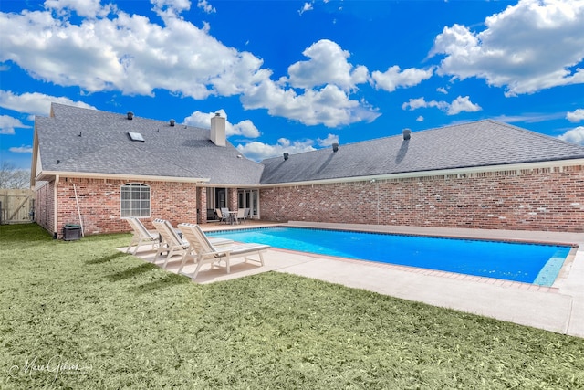 view of pool with a patio, central AC, fence, a yard, and a fenced in pool