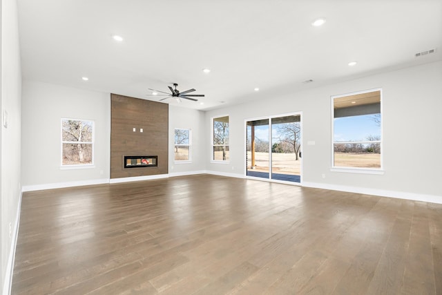 unfurnished living room featuring hardwood / wood-style flooring, a fireplace, and ceiling fan
