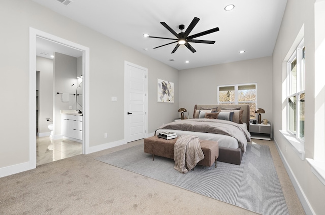 carpeted bedroom with ensuite bathroom and ceiling fan