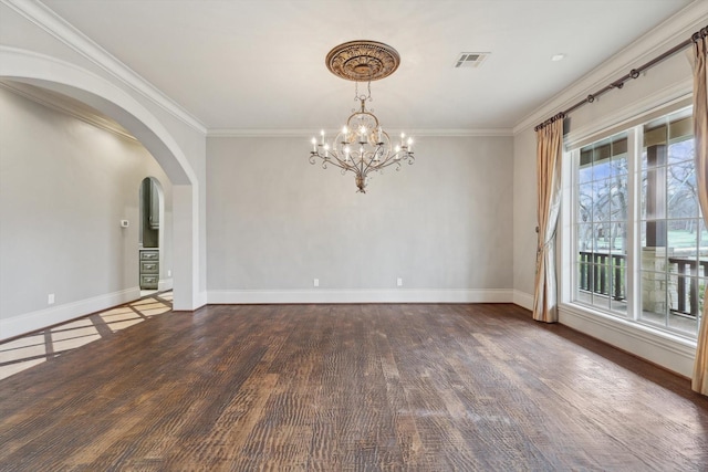 empty room featuring ornamental molding, dark wood-type flooring, and an inviting chandelier