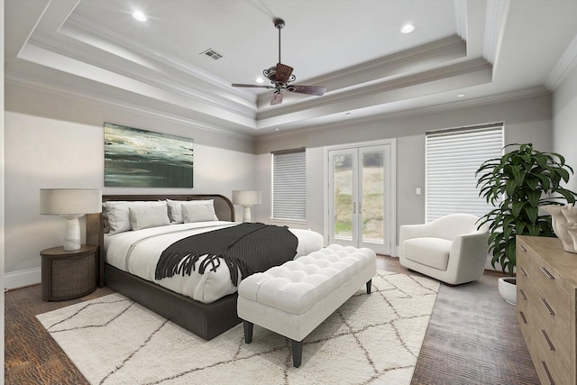 bedroom with ceiling fan, a tray ceiling, wood-type flooring, access to outside, and french doors