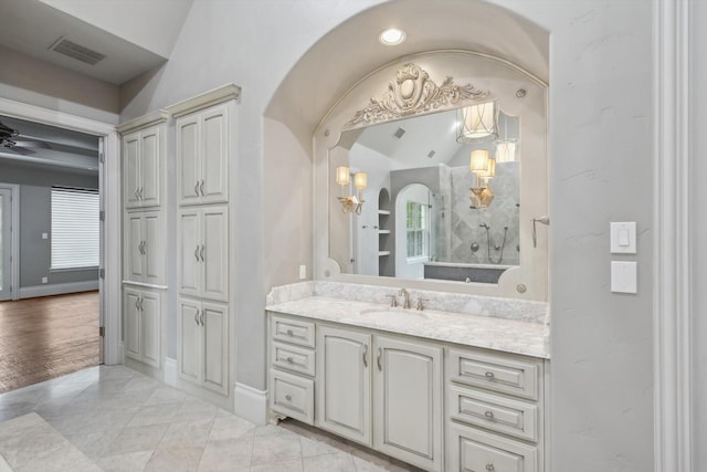 bathroom with vanity, vaulted ceiling, tile patterned floors, and ceiling fan