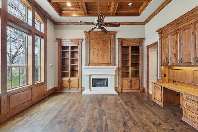 unfurnished office with coffered ceiling, crown molding, built in desk, dark hardwood / wood-style floors, and a high ceiling