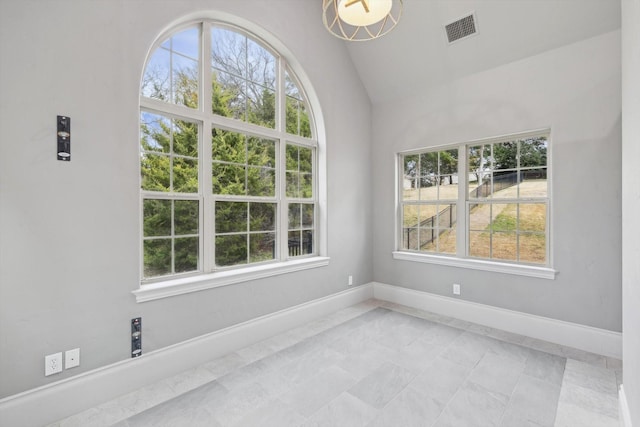 empty room featuring vaulted ceiling and a healthy amount of sunlight