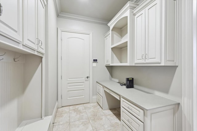 mudroom with crown molding and built in desk