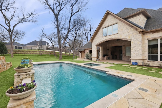 view of pool with an in ground hot tub, a yard, and a patio