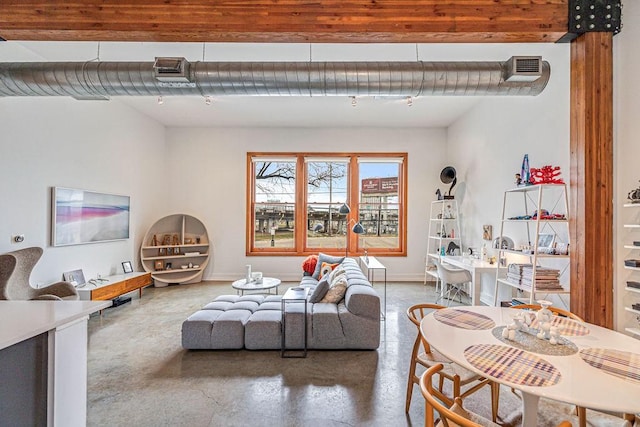 living area featuring visible vents, baseboards, and concrete flooring