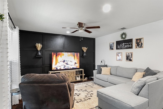 living room featuring wood-type flooring and ceiling fan