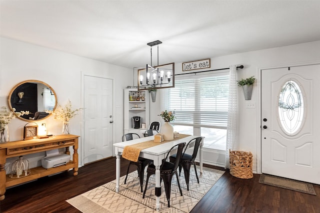 dining area featuring an inviting chandelier and dark hardwood / wood-style flooring