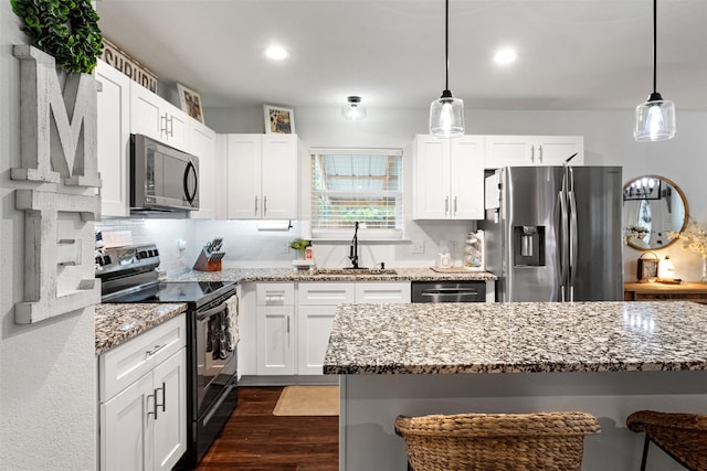 kitchen featuring white cabinetry, stainless steel appliances, tasteful backsplash, light stone countertops, and decorative light fixtures