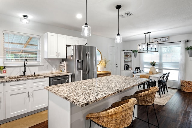 kitchen with a kitchen island, white cabinetry, appliances with stainless steel finishes, and sink