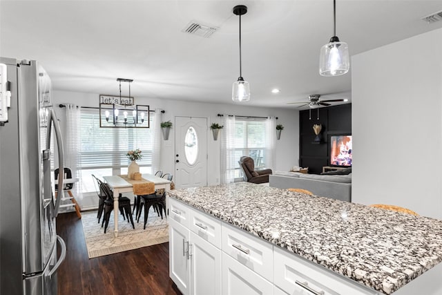 kitchen featuring stainless steel refrigerator with ice dispenser, dark hardwood / wood-style floors, pendant lighting, and white cabinets