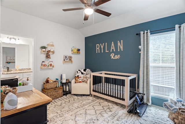 bedroom with lofted ceiling, a nursery area, and ceiling fan