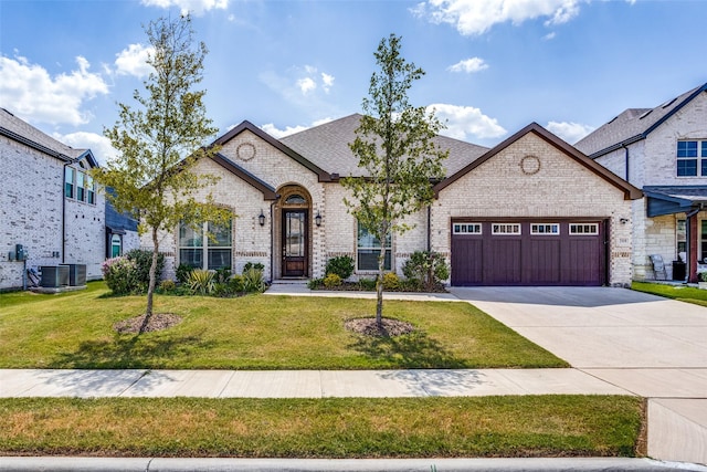 french provincial home featuring cooling unit, a garage, and a front yard