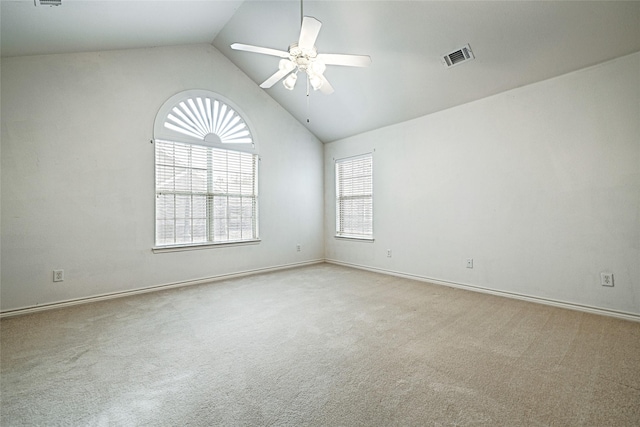 spare room featuring vaulted ceiling, light carpet, and ceiling fan