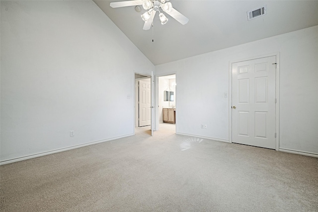 unfurnished bedroom with high vaulted ceiling, ensuite bath, light colored carpet, and ceiling fan