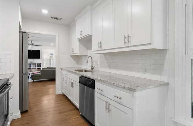 4217 Winfield Ave, Fort Worth, TX 76109 - kitchen with a sink, appliances with stainless steel finishes, white cabinetry, wood finished floors, and recessed lighting