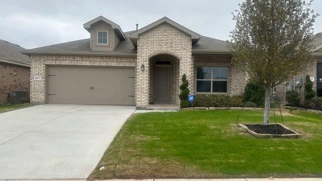 view of front of house with a garage, central AC, and a front yard