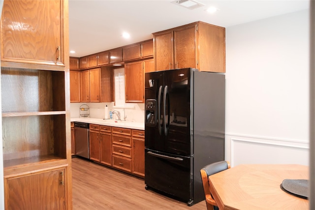 kitchen with sink, dishwasher, black refrigerator with ice dispenser, and light hardwood / wood-style flooring