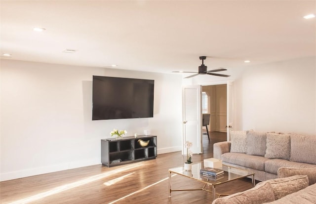 living room featuring hardwood / wood-style floors and ceiling fan