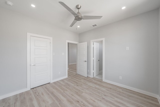 unfurnished bedroom featuring ceiling fan, ensuite bath, and light wood-type flooring