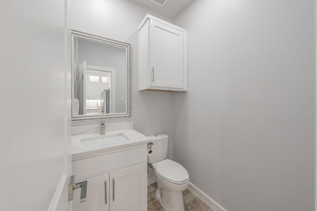 bathroom with hardwood / wood-style flooring, vanity, and toilet