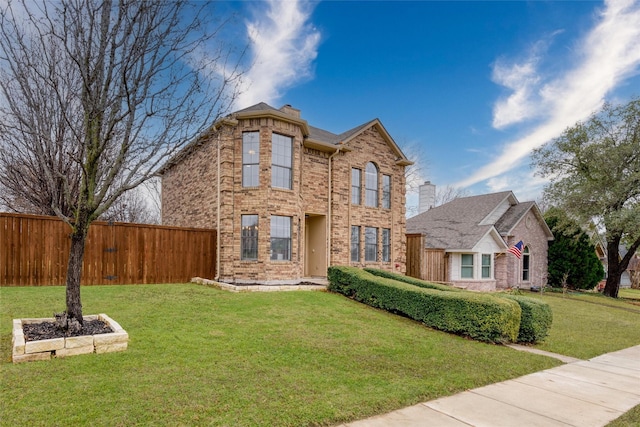 traditional-style home with a front yard, brick siding, fence, and a chimney