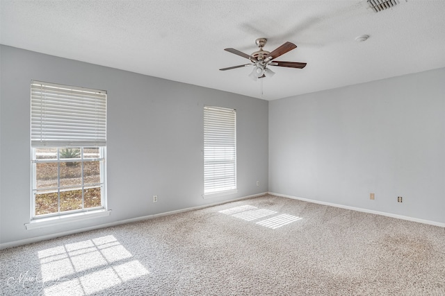 carpeted spare room featuring ceiling fan and a textured ceiling