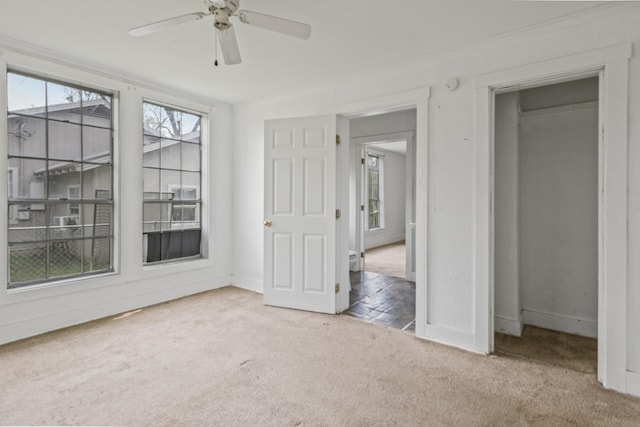 interior space with carpet floors, baseboards, and ceiling fan