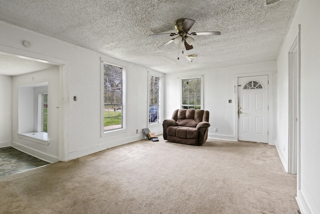 unfurnished room featuring baseboards, ceiling fan, carpet flooring, and a textured ceiling