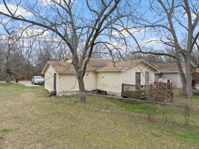 view of property exterior featuring a lawn and a deck