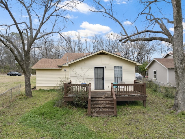 rear view of house with a lawn and a deck