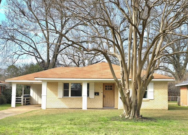 ranch-style home featuring a carport and a front yard