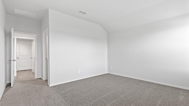 carpeted empty room with vaulted ceiling