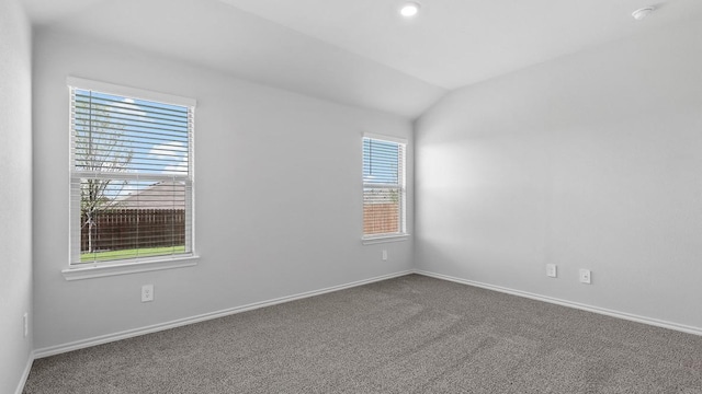 unfurnished room with lofted ceiling and carpet flooring